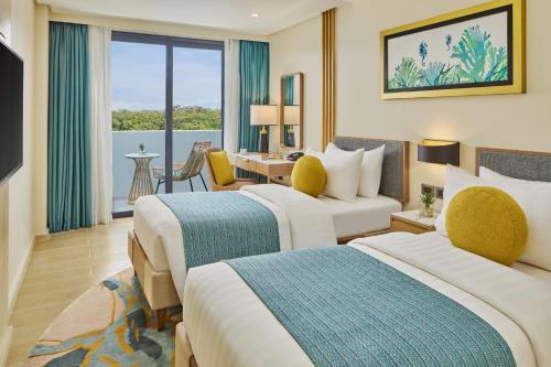 a hotel room with two beds and a desk at Chancellor Hotel Boracay in Boracay