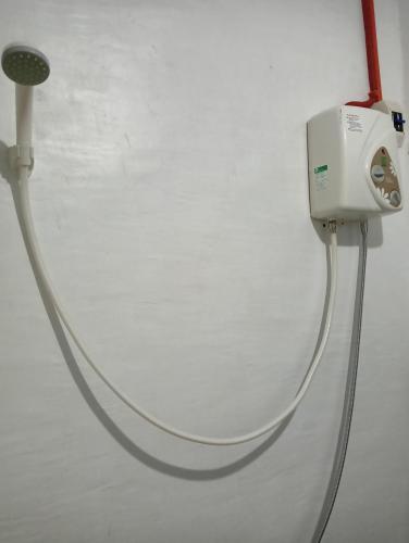 a white hose is hooked up to a wall at RM Homestay in Siquijor