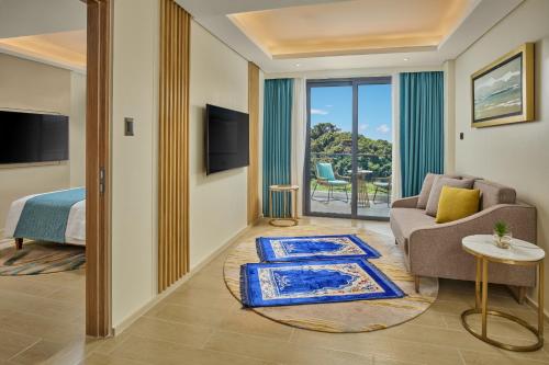 a living room with a couch and a bed and a television at Chancellor Hotel Boracay in Boracay
