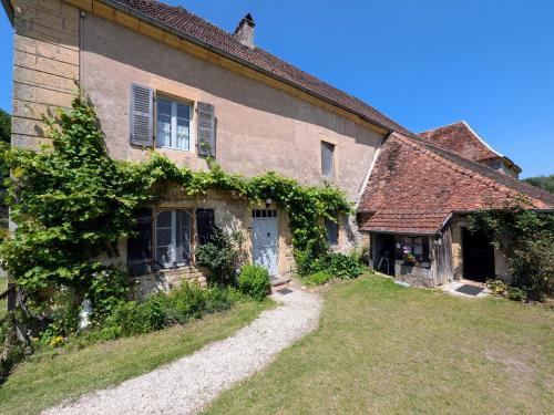 an old house with ivy on the side of it at Gîte paisible près des forêts - FR-1-583-504 in Montigny-les Cherlieux