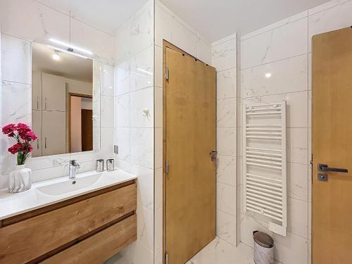 une salle de bain avec un lavabo et un miroir dans l'établissement Bel appartement neuf proche du domaine skiable avec parking - FR-1-560-160, à Combloux