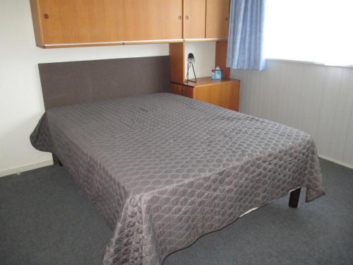 - une chambre avec un lit et une couette brune dans l'établissement Appartement 4 pers près centre et pistes, navette, parking, lave-vaisselle - FR-1-814-74, à Besse-et-Saint-Anastaise
