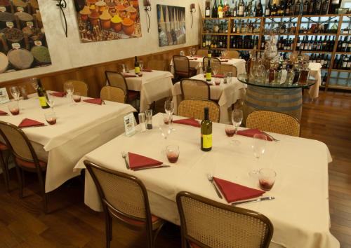 a dining room with white tables and red napkins at Hotel Bahnhof Haus in Chiasso