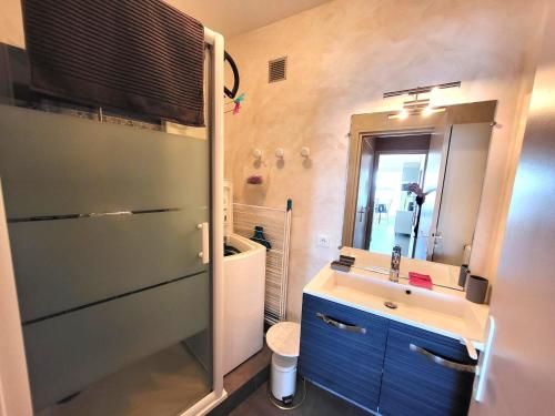 une salle de bain avec un lavabo et un miroir dans l'établissement Studio rénové face à la plage avec balcon et garage - FR-1-92-948, à Les Sables-dʼOlonne