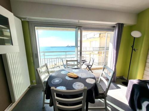 une salle à manger avec une table et une vue sur l'océan dans l'établissement Studio rénové face à la plage avec balcon et garage - FR-1-92-948, à Les Sables-dʼOlonne