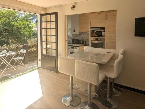 une cuisine avec une table et des chaises dans une pièce dans l'établissement Studio Charmant Proche Plage pour 2 Pers avec Parking - FR-1-420-159, à Arcachon