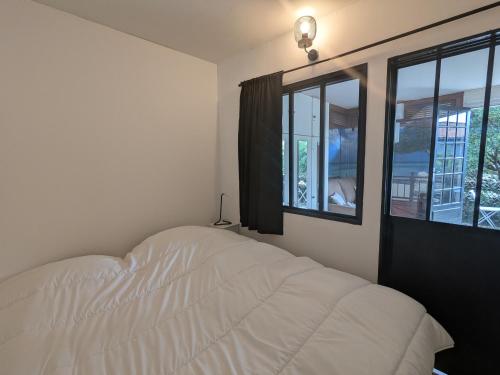 une chambre avec un lit blanc et une fenêtre dans l'établissement Studio Charmant Proche Plage pour 2 Pers avec Parking - FR-1-420-159, à Arcachon