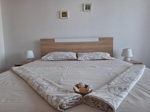 a bed with a blanket and a bowl on it at Condo Santosha on the beach in Pomorie