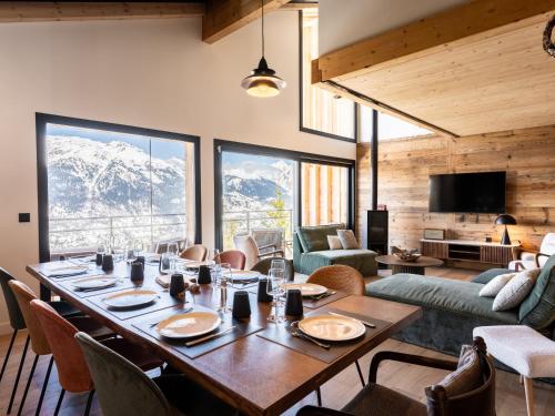 - une salle à manger avec une table, des chaises et des montagnes dans l'établissement Chalet neuf à La Plagne, accès direct aux pistes, sauna, parking, 5 chambres - FR-1-755-39, à Aime La Plagne