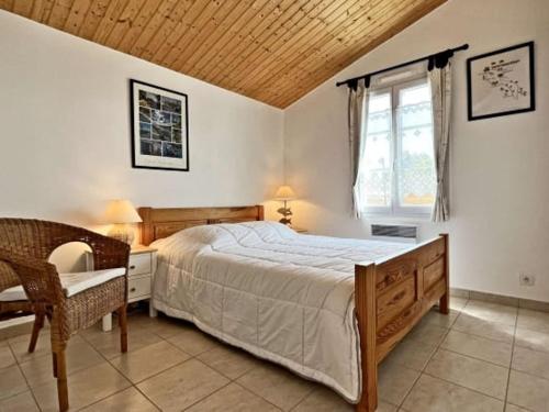 une chambre avec un lit, une chaise et une fenêtre dans l'établissement Maison confortable 4 pers. avec jardin proche plage Noirmoutier - FR-1-823-99, à Noirmoutier-en-l'lle