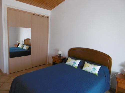 une chambre avec un lit bleu et un miroir dans l'établissement Maison confortable à Noirmoutier pour 6 pers., proche plage - FR-1-823-104, à Noirmoutier-en-l'lle