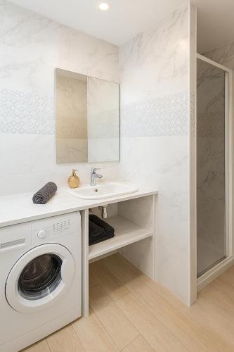 une salle de bain avec une machine à laver et un lavabo dans l'établissement Appartement 3 chambres, 9P, Hyper centre Disney, à Chessy