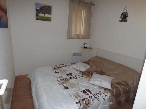 - une chambre dotée d'un lit avec des draps blancs dans l'établissement Appartement pour 4 avec piscine et parking aux Saintes-Maries-de-la-Mer - FR-1-475-201, à Saintes-Maries-de-la-Mer