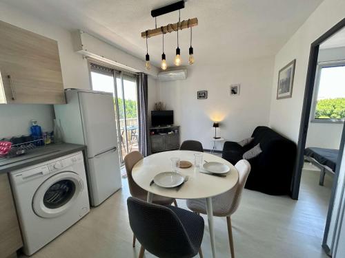 une cuisine et un salon avec une table et une salle à manger dans l'établissement Appartement 2 pièces, climatisé, proche plage et parking à Saint Cyprien - FR-1-225D-226, à Saint-Cyprien