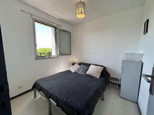 une chambre avec un lit et une fenêtre dans l'établissement Appartement 2 pièces, climatisé, proche plage et parking à Saint Cyprien - FR-1-225D-226, à Saint-Cyprien