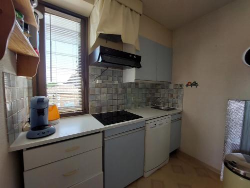 a small kitchen with white appliances and a window at Appartement T2 au centre de Vieux-Boucau avec parking privé, proche des plages - FR-1-239-1136 in Vieux-Boucau-les-Bains