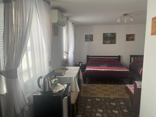 a room with a bed and a table and a window at Parusa Maklaia in Baturyn