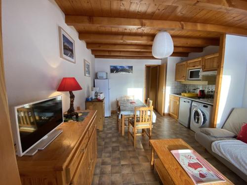 Il comprend une cuisine et un salon avec une télévision et une table. dans l'établissement Appartement pour 4 pers., 2 chambres, parking inclus - FR-1-733-168, à Crest-Voland