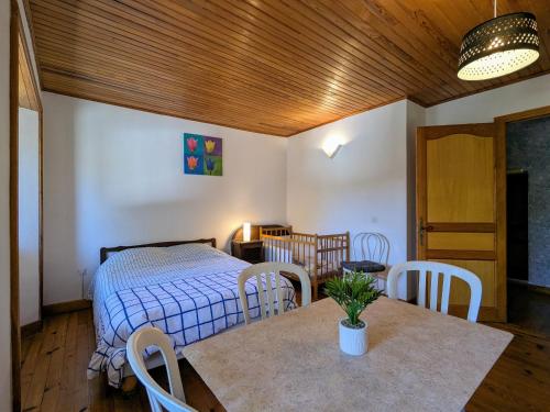 a bedroom with a bed and a table and chairs at Séjour rustique proche des Estables et du Puy-en-Velay - FR-1-582-533 in Saint-Front