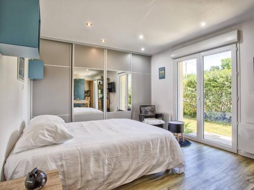 Un dormitorio con una cama grande y una ventana grande. en Votre Havre de Paix à Merville proche de la Mer - FR-1-788-82, en Merville-Franceville-Plage