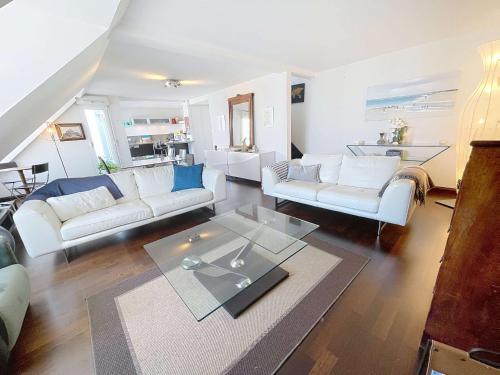 un salon avec des canapés blancs et une table dans l'établissement Duplex T3 avec terrasse, vue sur Granville et Wifi - FR-1-361-566, à Granville