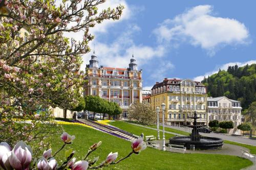 a large building with a fountain in the middle of a park at Ensana Hvězda - Imperiál - Neapol in Mariánské Lázně