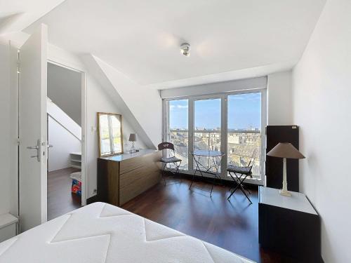 une chambre avec un lit, un bureau et une fenêtre dans l'établissement Duplex T3 avec terrasse, vue sur Granville et Wifi - FR-1-361-566, à Granville