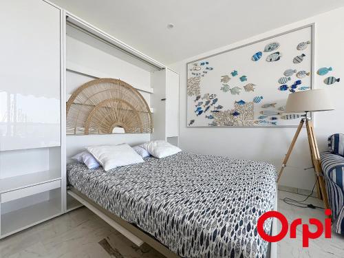 ein Schlafzimmer mit einem Bett und einem Bild an der Wand in der Unterkunft Studio moderne avec terrasse, climatisé, WIFI, 2 couchages à Menton - FR-1-647-50 in Menton