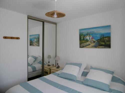 une chambre avec deux lits et un tableau au mur dans l'établissement Maison Noirmoutier entre Bourg et Plage, 4/6 pers, jardin, parking, TV, WiFi - FR-1-823-70, à Noirmoutier-en-l'lle