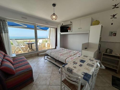 Cette chambre comprend un lit, une table et un canapé. dans l'établissement Studio bord de mer avec parking - Saint-Jean-de-Monts - FR-1-224C-347, à Saint-Jean-de-Monts