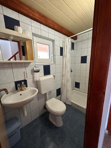 a bathroom with a toilet and a sink and a tub at Vila Rosa in Tkon