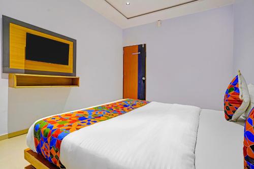 a bedroom with a bed with a colorful blanket at FabHotel Nidhivan Palace - Udhna Darwaja in Surat