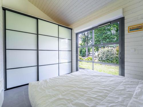 a bedroom with a bed and a large window at Maison confortable pour 6 pers., proche lac de Gastes - FR-1-50-187 in Gastes