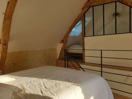 a bed in a room with a window at Maison d'hôtes près de La Flèche avec animaux acceptés - FR-1-410-474 in Cré-sur-Loir
