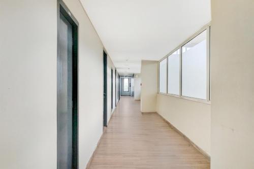 a long hallway with white walls and wood floors at Super Townhouse MG Road Pune in Pune