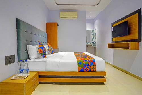 a bedroom with a large bed and a tv at FabHotel Nidhivan Palace - Udhna Darwaja in Surat