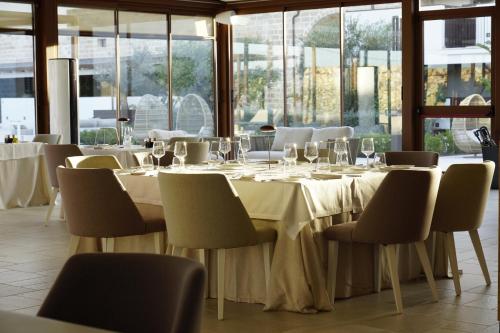 a dining room with a table and chairs and windows at Masseria Corsano in Nardò