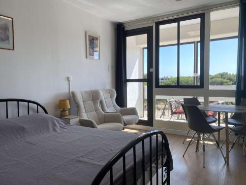 une chambre avec un lit, une table et des chaises dans l'établissement Studio vue parc avec climatisation - FR-1-553-305, à Balaruc-les-Bains