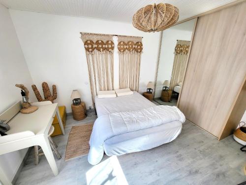 une chambre avec un lit, un bureau et un miroir dans l'établissement Maison de pêcheur moderne avec terrasse, proche mer et commerce - Barbecue - WIFI Gratuit - FR-1-92-950, à Les Sables-dʼOlonne