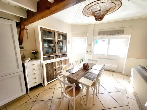 une cuisine et une salle à manger avec une table et des chaises dans l'établissement Maison de pêcheur moderne avec terrasse, proche mer et commerce - Barbecue - WIFI Gratuit - FR-1-92-950, à Les Sables-dʼOlonne