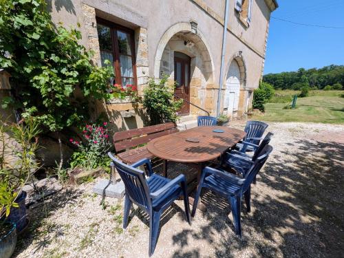 a wooden table and chairs in front of a building at Gîte paisible dans forêts avec vélos et randonnées, animaux admis - FR-1-583-503 in Montigny-les Cherlieux