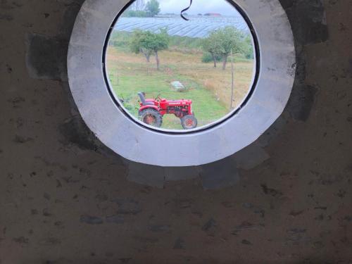 a round window with a tractor in a field at Maison d'hôtes près de La Flèche, adaptée PMR, animaux admis, petit-déjeuner inclus - FR-1-410-475 in Cré-sur-Loir