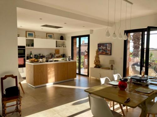 Il comprend une cuisine et une salle à manger avec une table. dans l'établissement Villa spacieuse à Carqueiranne pour 10 pers, proche mer - FR-1-599-120, à Carqueiranne