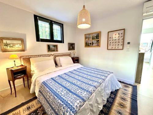 ein Schlafzimmer mit einem Bett, einem Tisch und einer Lampe in der Unterkunft Villa spacieuse à Carqueiranne pour 10 pers, proche mer - FR-1-599-120 in Carqueiranne