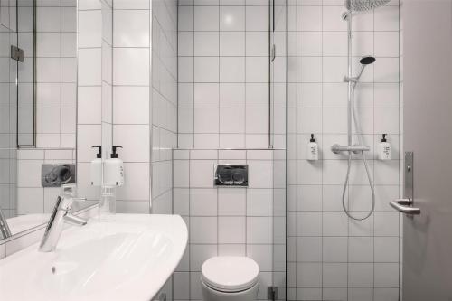 a bathroom with a shower and a sink and a toilet at Scandic Sunnfjord Hotel & Spa in Førde