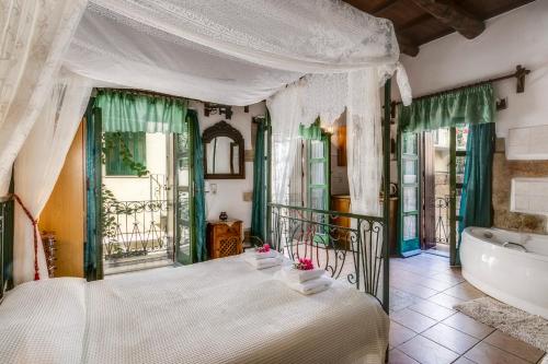 a bedroom with a large bed and a tub at IFIGENIA ROOMS BY MARIOS in Chania Town