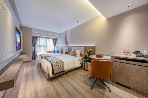 a hotel room with a bed and a desk at Kunming Meihao Lizhi Hotel Cuihu Park Yunnan University Hospital Branch in Kunming