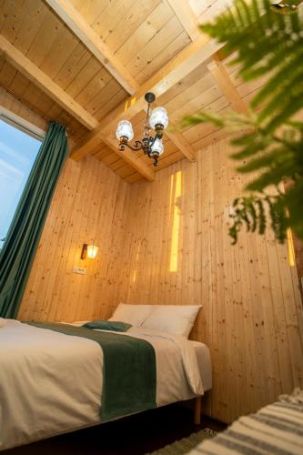 a bedroom with a bed in a wooden wall at Cabana Oul Arsitei in Pleşi
