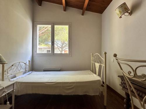 une chambre à l'hôpital avec un lit et une fenêtre dans l'établissement Villa à La Palmyre pour 7 pers, animaux admis, parking, clim, WiFi - FR-1-705-102, aux Mathes