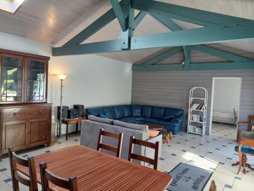 un salon avec un canapé bleu et une table dans l'établissement sable gris maison d'architecte, à Andernos-les-Bains